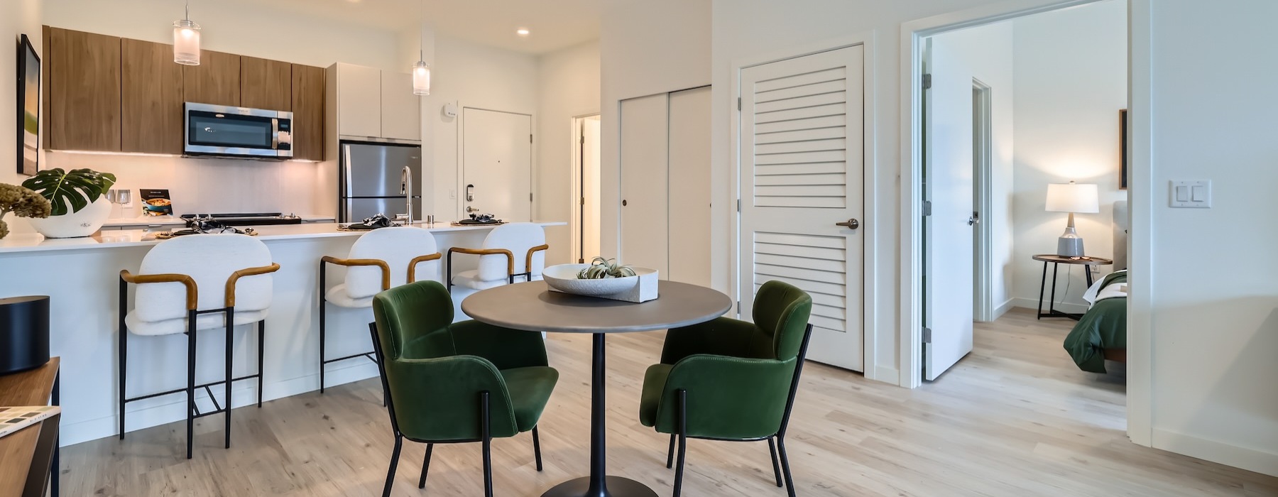 a large living area with a small two-seat table and an island