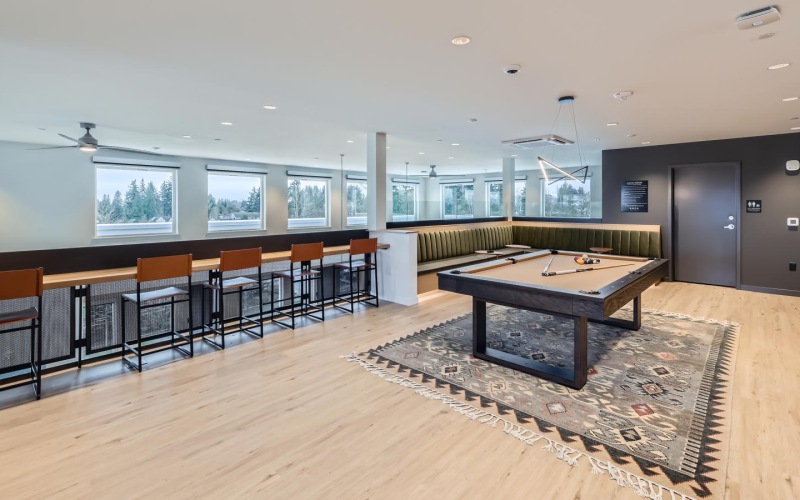 a room with a pool table and chairs