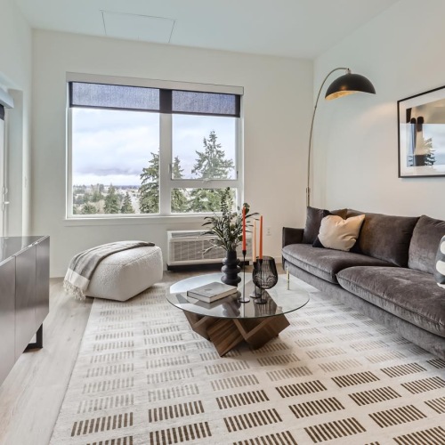 a spacious living room with a large window and high ceilings