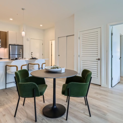 a large living area with a small two-seat table and an island