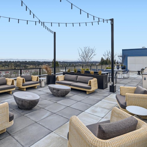 a rooftop lounge space with hanging lights