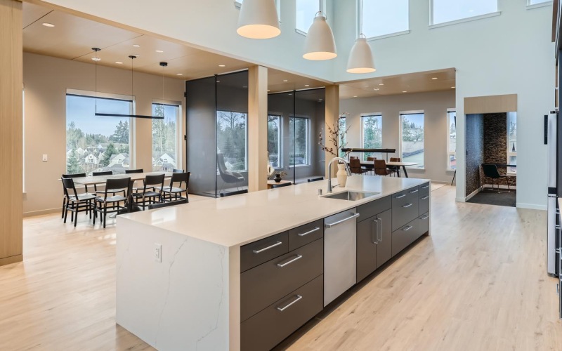 a spacious room with ample lighting and a resident kitchen